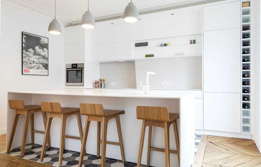 Cuisine contemporaine de couleur blanche avec bar désignée par un architecte d'intérieur à Paris