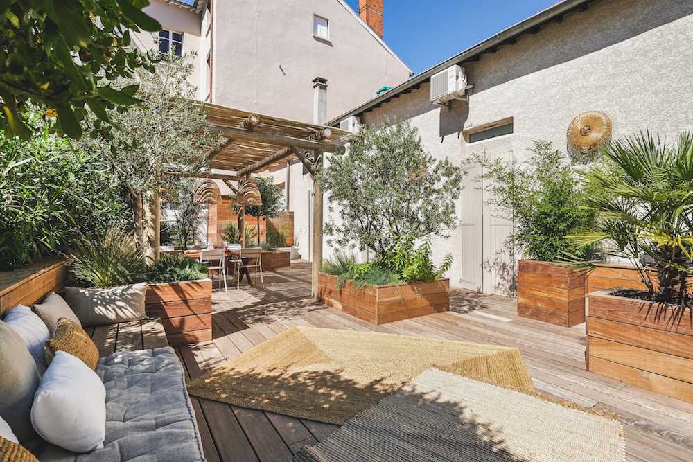 Aménagement d'une terrasse en bois - esprit méditérranéen - espace détente avec végétation